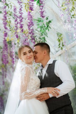 young couple the groom in a plaid suit and the bride in a chic white dress in nature