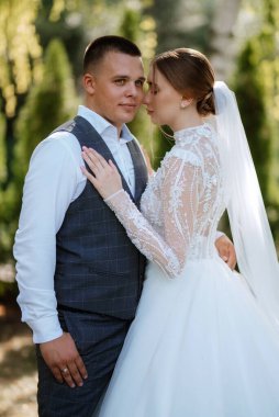 young couple the groom in a plaid suit and the bride in a chic white dress in nature
