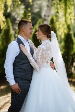 young couple the groom in a plaid suit and the bride in a chic white dress in nature