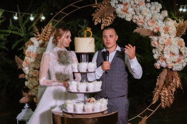 newlyweds happily cut, laugh and taste the wedding cake