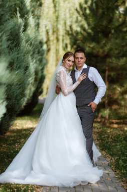 young couple the groom in a plaid suit and the bride in a chic white dress in nature