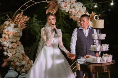 newlyweds happily cut, laugh and taste the wedding cake