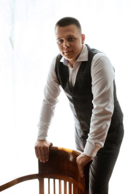 portrait of the groom of a man in the morning before the wedding in a gray plaid three-piece suit