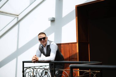 portrait of the groom of a man in the morning before the wedding in a gray plaid three-piece suit