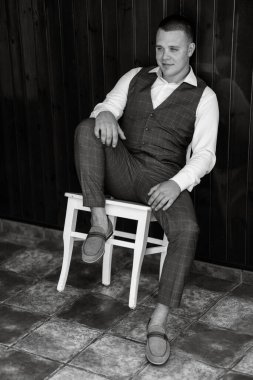 portrait of the groom of a man in the morning before the wedding in a gray plaid three-piece suit