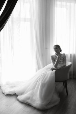 portrait of a bride in the morning before the wedding with putting on a white dress