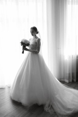 portrait of a bride in the morning before the wedding with putting on a white dress
