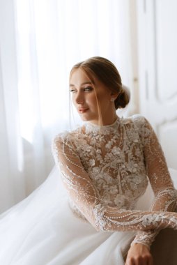 portrait of a bride in the morning before the wedding with putting on a white dress