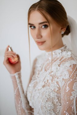 portrait of a bride in the morning before the wedding with putting on a white dress