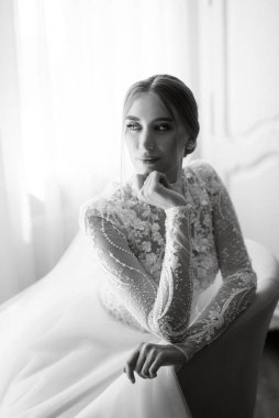 portrait of a bride in the morning before the wedding with putting on a white dress