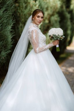 portrait of a bride in the morning before the wedding with putting on a white dress