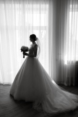 portrait of a bride in the morning before the wedding with putting on a white dress