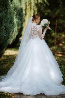 portrait of a bride in the morning before the wedding with putting on a white dress