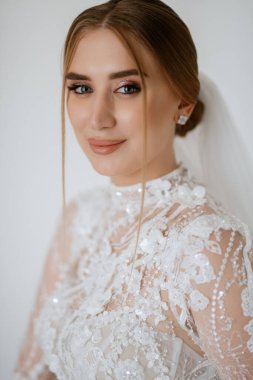 portrait of a bride in the morning before the wedding with putting on a white dress