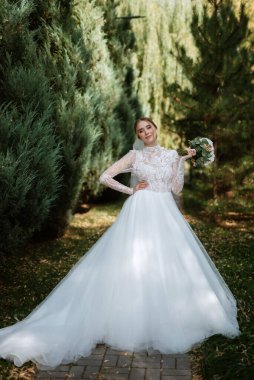 portrait of a bride in the morning before the wedding with putting on a white dress