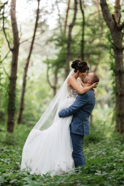 wedding walk of the bride and groom in the deciduous forest in summer