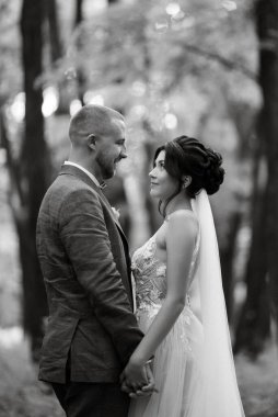 wedding walk of the bride and groom in the deciduous forest in summer