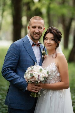 wedding walk of the bride and groom in the deciduous forest in summer