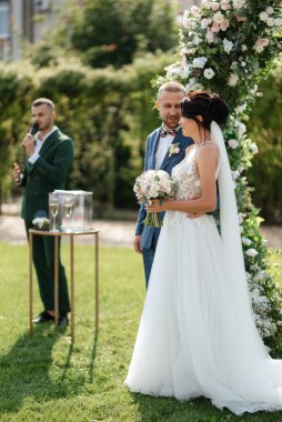 wedding ceremony of the newlyweds on the glade near the restaurant