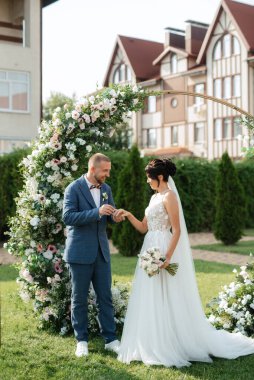 wedding ceremony of the newlyweds on the glade near the restaurant