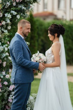 wedding ceremony of the newlyweds on the glade near the restaurant
