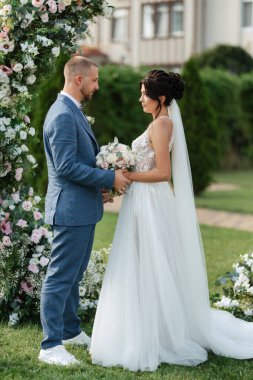 wedding ceremony of the newlyweds on the glade near the restaurant