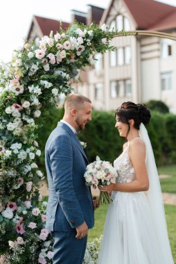 wedding ceremony of the newlyweds on the glade near the restaurant