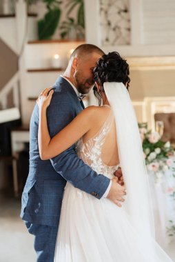 the first dance of the bride and groom inside a restaurant with heavy smoke