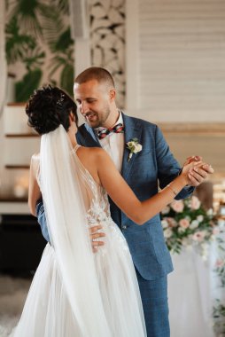 the first dance of the bride and groom inside a restaurant with heavy smoke