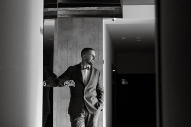 portrait of smiling groom with beard in blue color suit