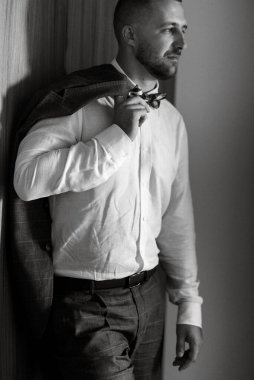 portrait of smiling groom with beard in blue color suit