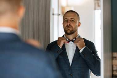 portrait of smiling groom with beard in blue color suit