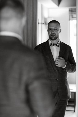 portrait of smiling groom with beard in blue color suit