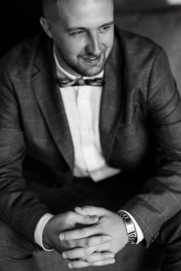 portrait of smiling groom with beard in blue color suit