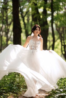 portrait of an elegant bride girl on a path in a deciduous forest