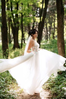 portrait of an elegant bride girl on a path in a deciduous forest