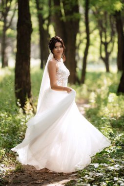 portrait of an elegant bride girl on a path in a deciduous forest
