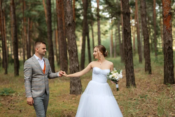 Junges Brautpaar Weißen Kurzen Kleid Und Bräutigam Grauen Anzug Kiefernwald — Stockfoto