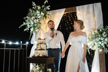 newlyweds happily cut, laugh and taste the wedding cake