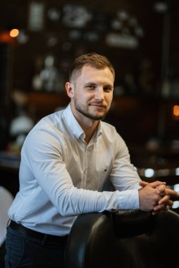 Berber dükkanındaki eğitim kampında tıraş olmuş ve stil yapmış genç bir adamın portresi.