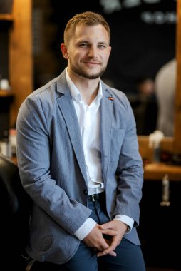 Berber dükkanındaki eğitim kampında tıraş olmuş ve stil yapmış genç bir adamın portresi.