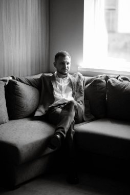 portrait of smiling groom with beard in blue color suit