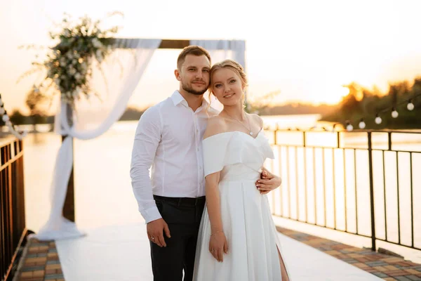 Bruid Bruidegom Tegen Achtergrond Van Een Gele Zonsondergang Een Pier — Stockfoto