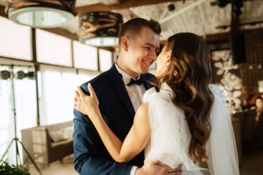 the first dance of the bride and groom inside a restaurant with heavy smoke