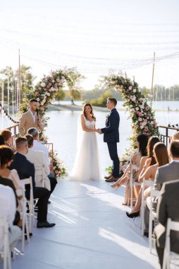 Nehrin yakınındaki yüksek bir rıhtımda davetlilerle düğün töreni.