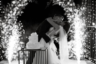 newlyweds happily cut, laugh and taste the wedding cake