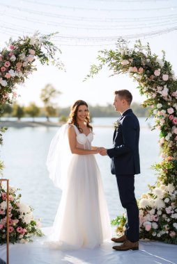 Nehrin yakınındaki yüksek bir rıhtımda davetlilerle düğün töreni.