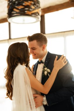the first dance of the bride and groom inside a restaurant with heavy smoke
