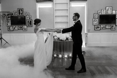 the first dance of the bride and groom inside a restaurant with heavy smoke