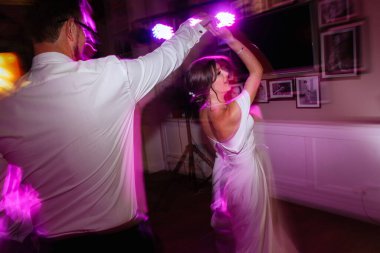 the first dance of the bride and groom inside a restaurant with heavy smoke